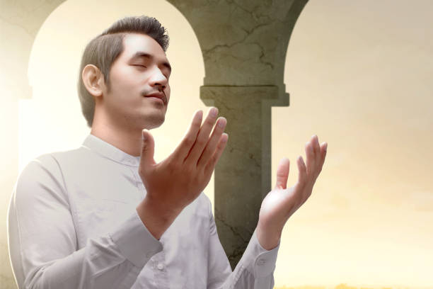 Young man on his knees in the pose of prayer.