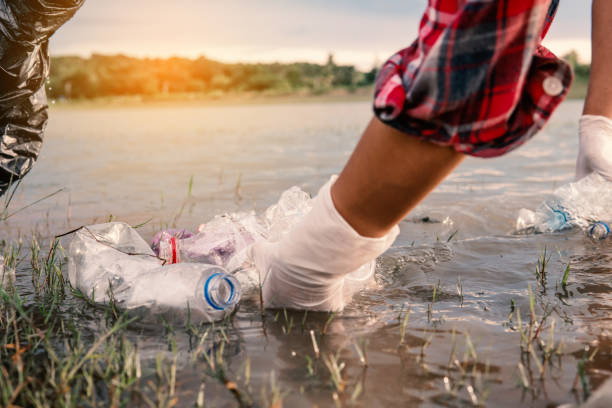 istock Human picking up a bottle plastic in the river , protect environment from a water pollution concept. 1169269884