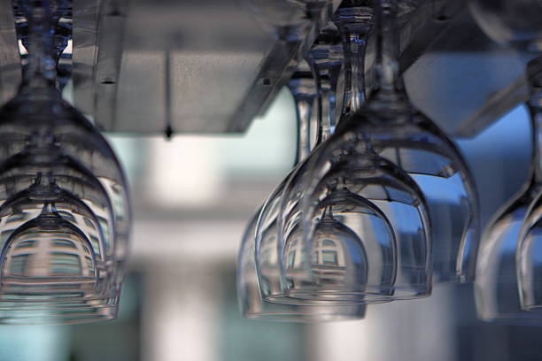 Wine glass stemware in restaurant nightclub hangs in rack in front of window through which muted colors from buildings across the street appear repeatedly to create a beautiful abstract.  Rochester, New York, 2008.