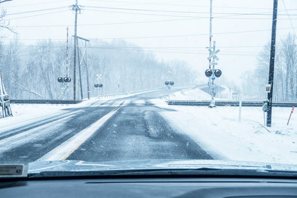 winter blizzard extreme weather rural highway railroad crossings - railroad crossing railway signal gate nobody imagens e fotografias de stock