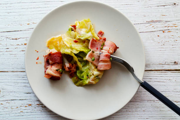 Salad with bacon and poached egg on a white plate