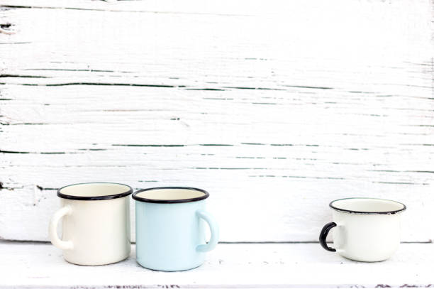 istock Enameled mugs in retro style on an old wooden background. 1169281146