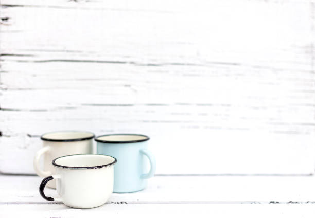 istock Enameled mugs in retro style on an old wooden background. 1169281148