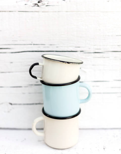istock Enameled mugs in retro style on an old wooden background. 1169281149