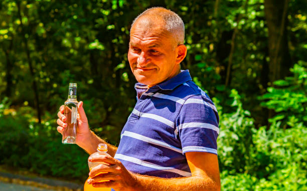 istock A man with a bottle of vodka in his hand. 1169281261