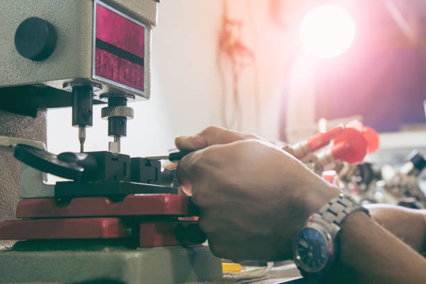 istock Locksmith in workshop makes new key. Professional making key in locksmith. 1169281301