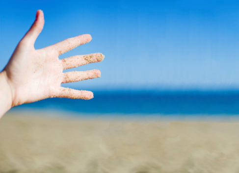 Sandy Hand at the beach, with plenty of copy space for your message