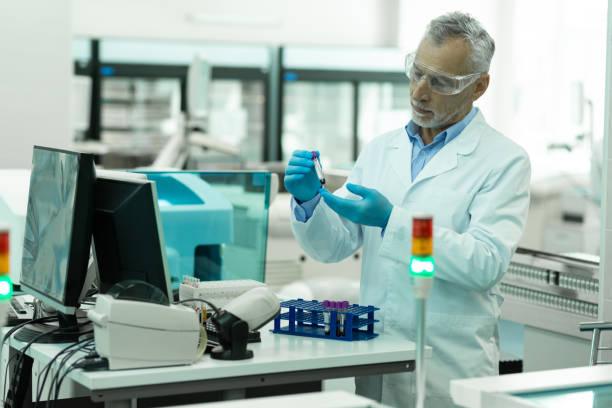 istock Attentive mature medical worker doing chemical experiment 1169293316