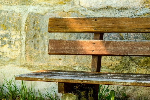 park bench at an old antique abbey wall