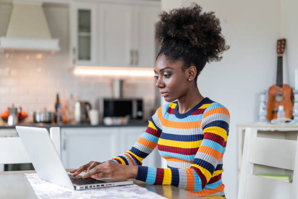 istock Afro Woman using laptop at home 1169296048
