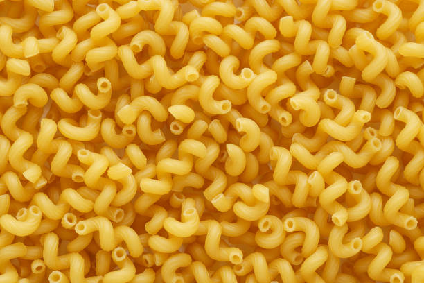 Dry uncooked cavatappi or cellentani pasta as a background. Flat lay.