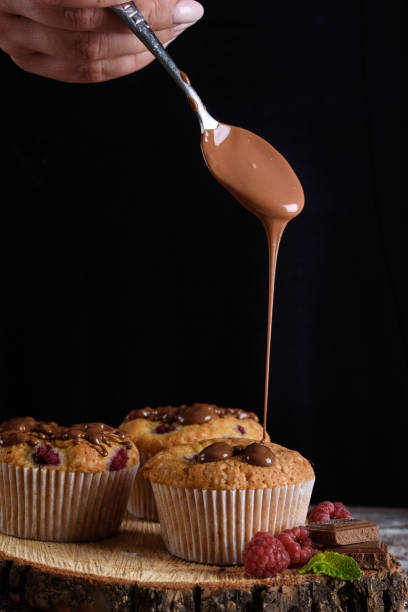 istock Delicious flavored cupcake with raspberries, white cream, and chocolate icing. 1169297407