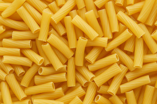 pasta seca sin cocinar tortiglioni o rigatoni como fondo. - rigatoni fotografías e imágenes de stock