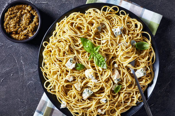 istock Spaghetti with genovese basil pesto and blue cheese on a black plate 1169298576
