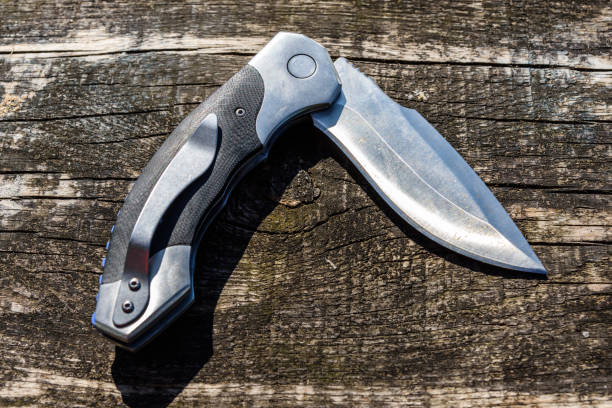 istock Folding knife on the rustic wooden background 1169299325