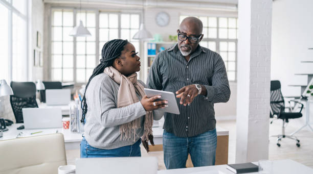 istock Senior african businessman discussing at work with his assistant 1169301164