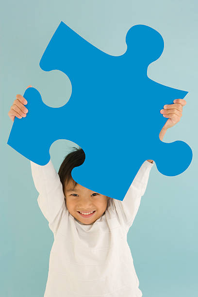 istock Young boy holding blue jigsaw piece 116930241