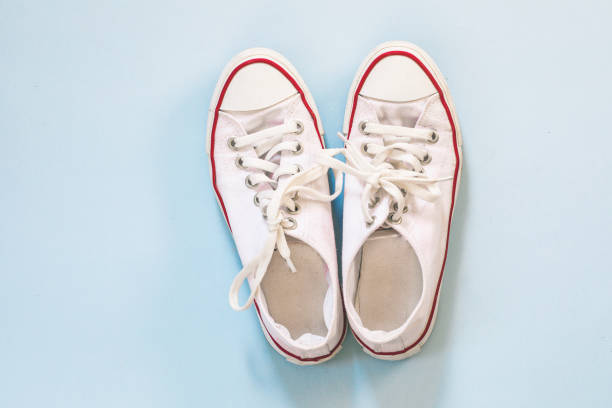 istock White canvas shoes on blue background 1169308370