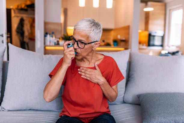 mulher asmática que usa um inalador - asthma inhaler - fotografias e filmes do acervo