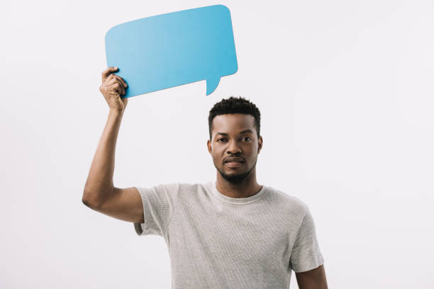 istock handsome african american man holding blue speech bubble isolated on white 1169310067