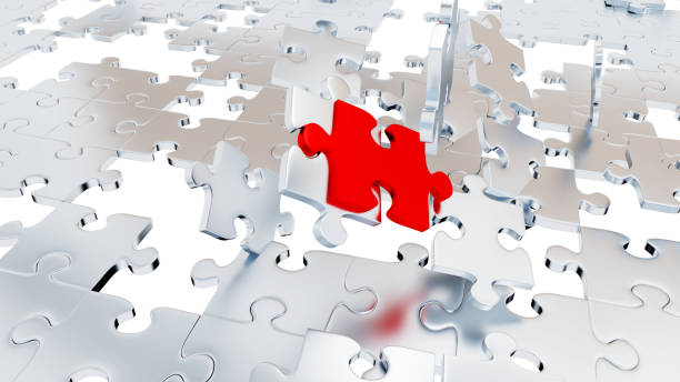 istock Several Chaotic Grey Puzzle pieces with many holes and one Red piece 1169312099