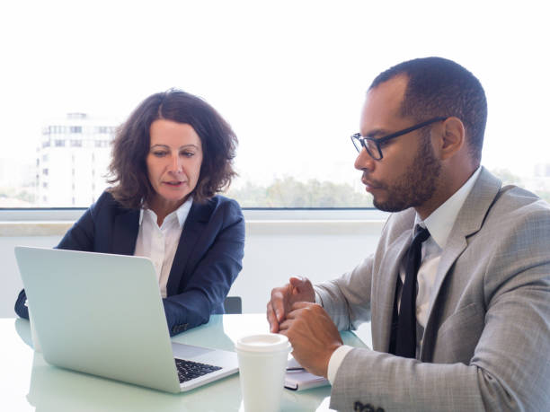 istock Female professional teaching male intern 1169313754