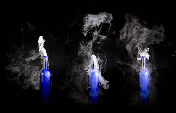 istock Blue wine bottles with white smoke billowing from opening 1169319132