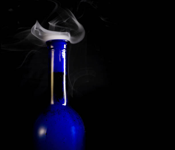 istock Blue wine bottles with white smoke billowing from opening 1169321740