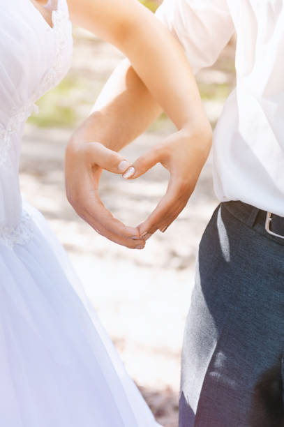 istock Couple making heart with hands, wedding photo. 1169325965