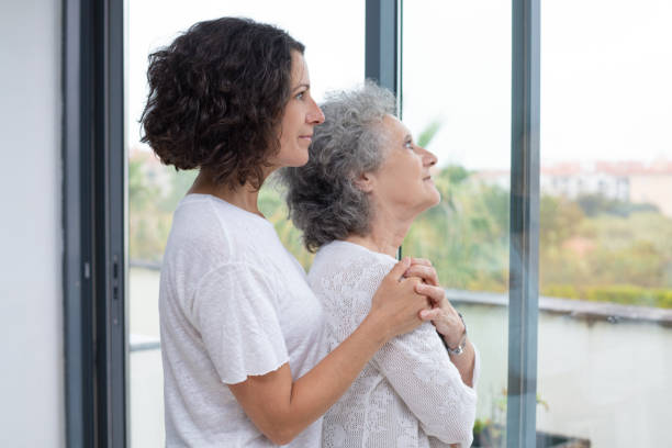 istock Mother and daughter looking at window 1169326013
