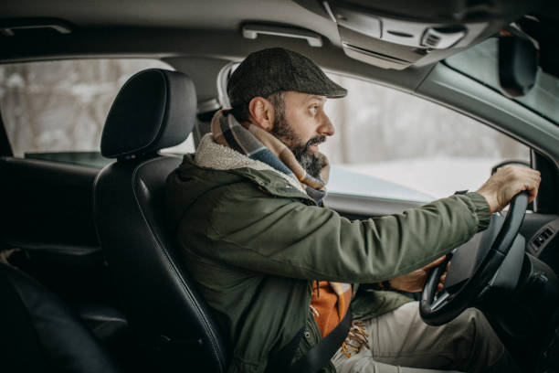istock Man driving car and talking 1169326277