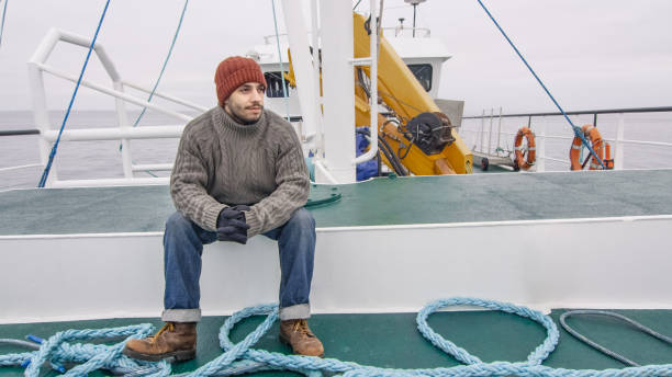상업용 선박의 벤치에 앉아있는 외로운 어부. - sea nautical vessel fisherman fishing industry 뉴스 사진 이미지
