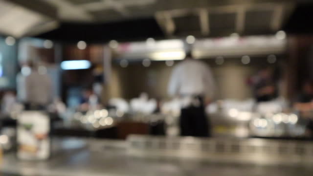 Chef cooking in restaurant kitchen blurred defocused background