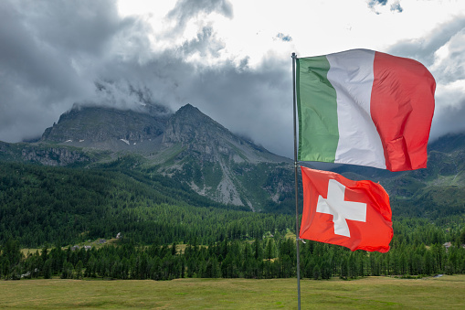 Italy August, 18  2019. Italian and Swiss flag at the border in the Alps. Natural park of Alpe Veglia