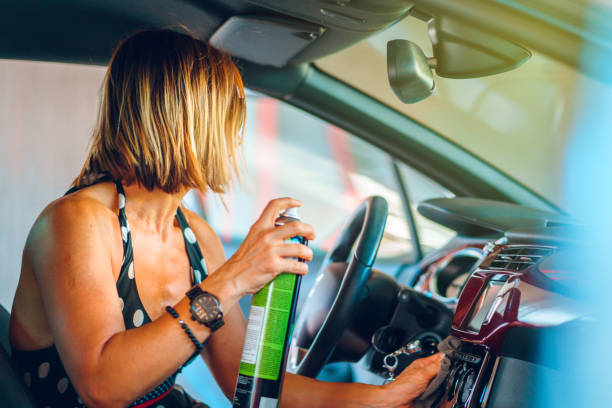 istock Woman cleaning her car cockpit using spray and microfiber cloth to clean and shine dashboard at self service car wash garage 1169326865