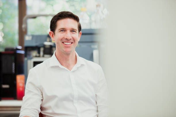 Cheerful Male Biochemist Male scientist smiling while looking at the camera while in a lab. He is a biochemist working in a university. biochemist stock pictures, royalty-free photos & images