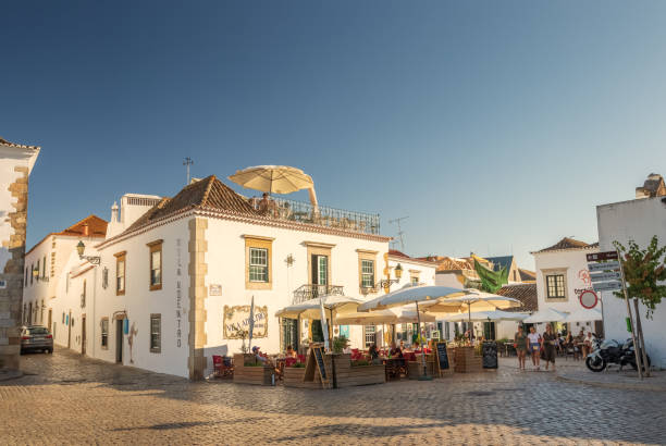 Old houses and restaurants in the historic area of Faro, Algarve, Portugal. Faro, Algarve, Portugal - July 25, 2019: Faro's old town, Dom Afonso III square, with old houses where restaurants and bars currently operate, with outdoor terraces and also on the terrace. Late afternoon on a summer day. faro district portugal photos stock pictures, royalty-free photos & images