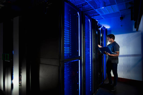 technicien masculin travaillant dans la salle de serveur - supercomputer photos et images de collection