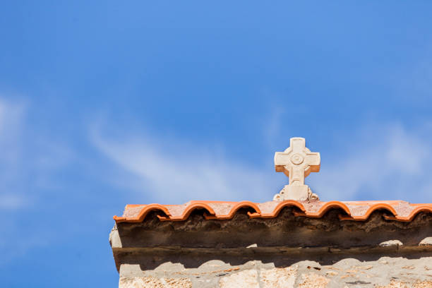 An old, ancient, medieval cross on roof. Signs, symbols of Christian culture.