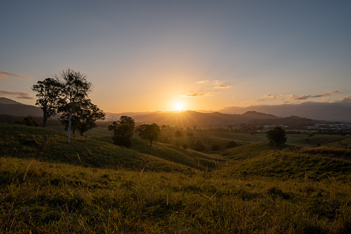 As the sun sets it casts beautiful colours and shadows across the farm fields and landscape of Murwillumbah, NSW, Australia.