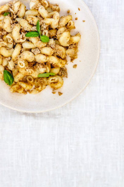 istock traditional soviet russian pasta dish, vermicelli, navy pasta, with meat on a white plate on a light fabric background. Minimalism View from above. 1169331230