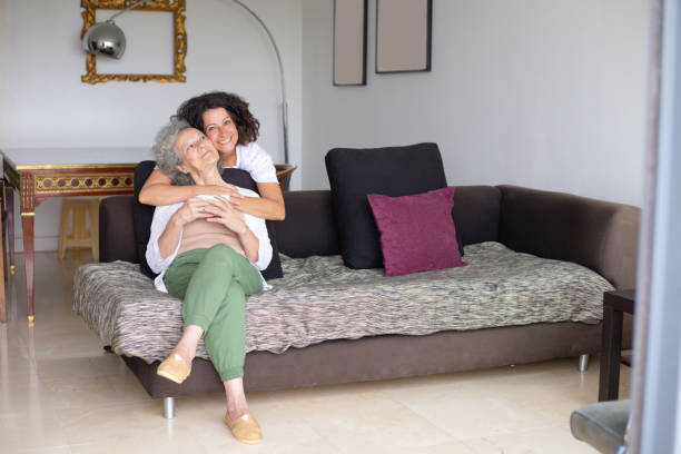 istock Happy mother and daughter hugging on couch 1169331969
