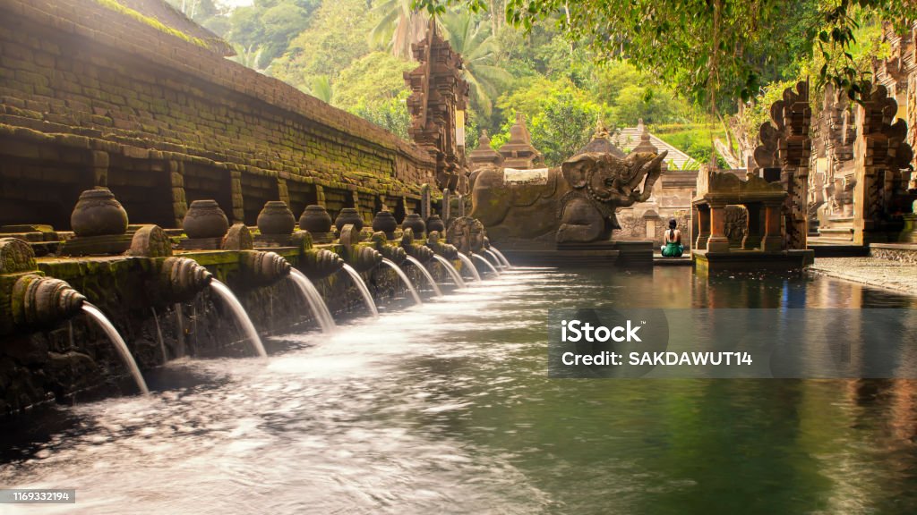 Balinese Hindu Temple Tirta Empul, Bali, Indonesia The holy spring water at the Tirta Empul temple near the city of Ubud, Bali, Indonesia, during a hot day on the tropical island. Bali Stock Photo