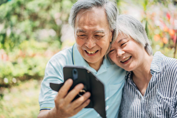 istock Married senior couple using smart phone in park 1169333441