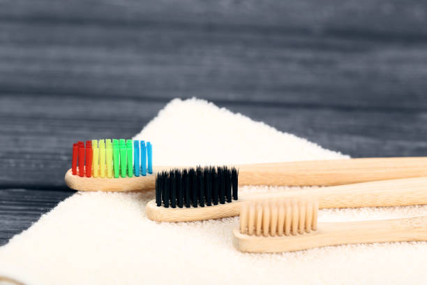 istock Bamboo toothbrushes with towel on black wooden table 1169337738