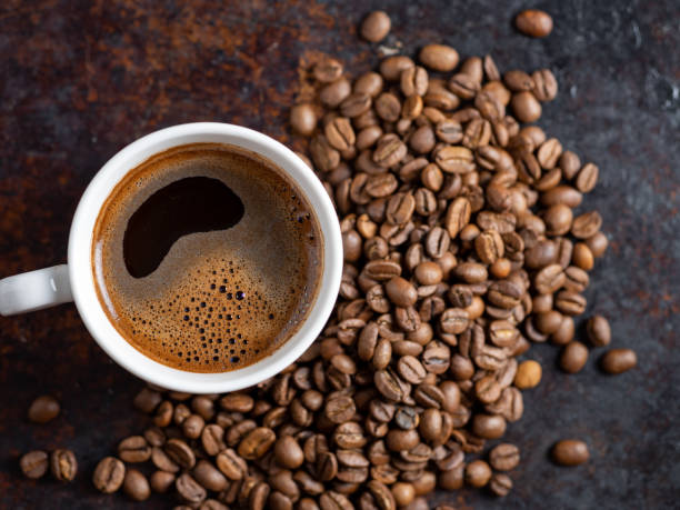 istock A Cup of espresso on a rusty background with scattered roasted coffee beans . copy space 1169339659