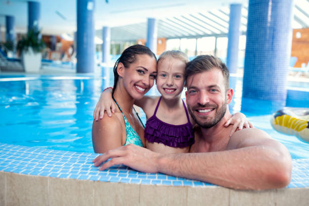 istock Happy family by the poolside 1169342255