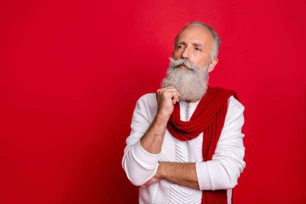 istock Portrait of his he nice attractive doubtful gray-haired man touching beard thinking creating decision isolated over bright vivid shine red background 1169342298