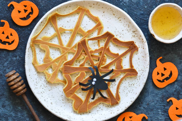 Halloween food for kids. Funny pancakes - spider web and spider. Breakfast for children. stock photo