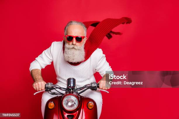 Foto de Feche Acima Da Foto Do Pensionista Fresco Que Monta Sua Bicicleta Com O Vento Do Ar Que Funde A Camisola Branca Da Ligação Em Ponte Isolada Sobre O Fundo Vermelho e mais fotos de stock de Natal